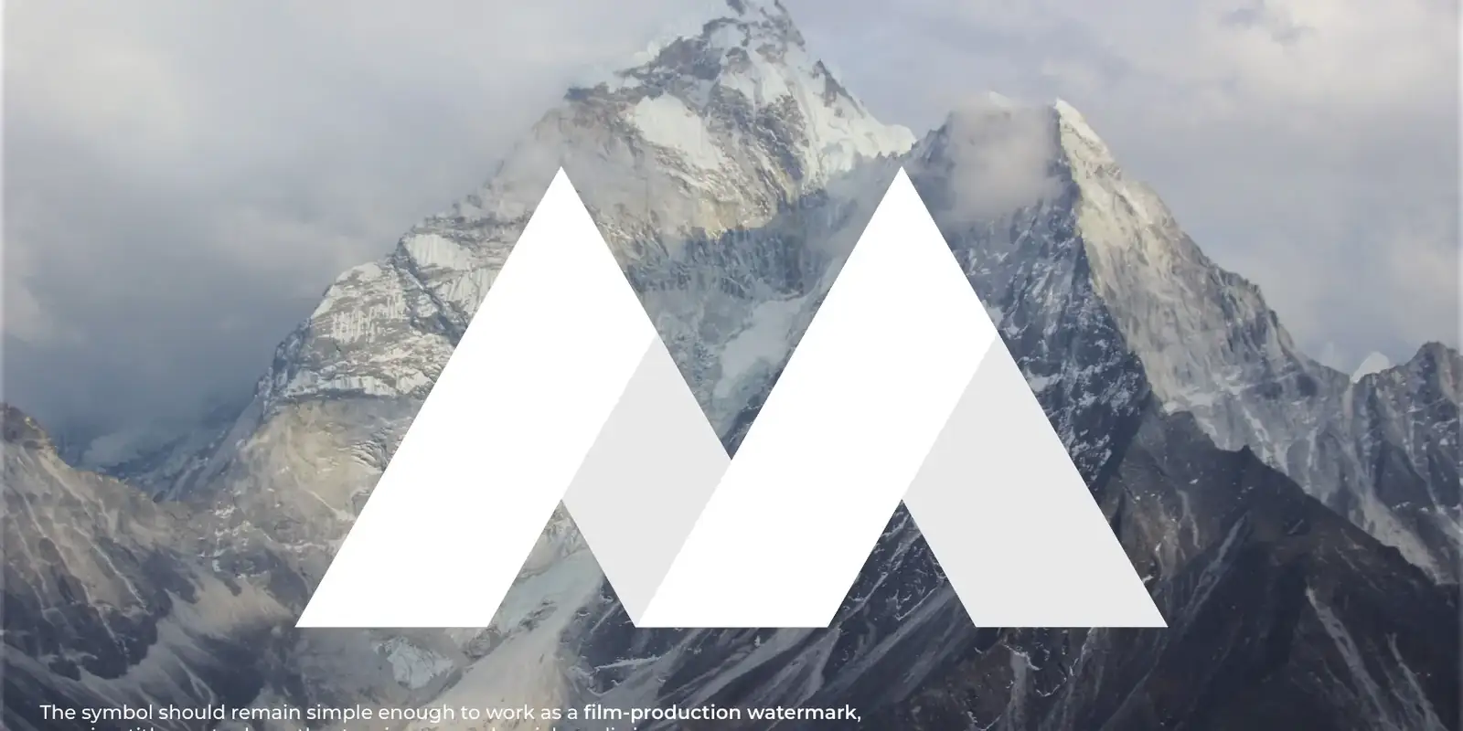 The M of the logo drawn from the peaks of Kailash Parvat